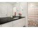 Bathroom with a large mirror, black countertop vanity and a shower at 14818 Dahlia St, Thornton, CO 80602