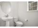 Charming powder room features a pedestal sink, round mirror, and a window at 14818 Dahlia St, Thornton, CO 80602