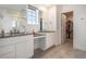 A luxurious bathroom featuring double vanity sinks with dark countertops and a walk-in closet at 14818 Dahlia St, Thornton, CO 80602