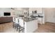 Modern kitchen featuring an island with bar stool seating and an open layout to the living area at 14818 Dahlia St, Thornton, CO 80602