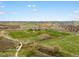 Aerial view of green land and community with a creek and a bridge at 13041 Reata Ridge Dr, Parker, CO 80134