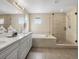 A modern bathroom with a double sink vanity, soaking tub, and glass-enclosed shower at 13041 Reata Ridge Dr, Parker, CO 80134