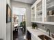 Butler's pantry with white cabinets, wine cooler, and sink at 13041 Reata Ridge Dr, Parker, CO 80134