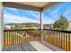 A relaxing outdoor deck with black railings offers beautiful views of the nearby green space and mountains at 1388 Castle Creek Cir, Castle Rock, CO 80104