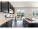 Modern kitchen with stainless steel appliances, white countertops, dark wood cabinets, and sliding glass doors to the outdoor deck at 1388 Castle Creek Cir, Castle Rock, CO 80104