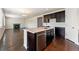 Kitchen island with stainless steel dishwasher and sink; living room visible with a fireplace and dark hardwood floors at 1388 Castle Creek Cir, Castle Rock, CO 80104