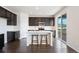 Modern kitchen with stainless steel appliances, dark wood cabinets, island with bar seating, and sliding glass doors to the outdoor deck at 1388 Castle Creek Cir, Castle Rock, CO 80104