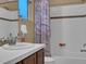 Bathroom featuring a sink with tiled countertop and shower with a shower curtain at 413 N De Gaulle Ct, Aurora, CO 80018