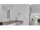 Bathroom with a vanity and mirror next to a doorway leading to a room with gray walls and wood floor at 413 N De Gaulle Ct, Aurora, CO 80018