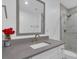 Bright bathroom features a modern vanity with a gray countertop and a tiled shower with glass door at 413 N De Gaulle Ct, Aurora, CO 80018