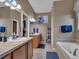 Well-lit bathroom with double sinks, a bathtub, and tasteful decor, creating a relaxing space at 413 N De Gaulle Ct, Aurora, CO 80018