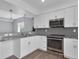 Kitchen with white cabinets, gray subway tile backsplash, and gray countertops at 413 N De Gaulle Ct, Aurora, CO 80018