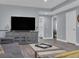 Living room featuring a large television, decorative cabinet, and modern decor at 413 N De Gaulle Ct, Aurora, CO 80018