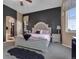 Elegant main bedroom featuring a tufted headboard, stylish decor, and a cozy ambiance, and ensuite bathroom at 413 N De Gaulle Ct, Aurora, CO 80018