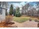 Well-manicured backyard features mature trees, green lawn, and brick patio for outdoor enjoyment at 2641 S Magnolia St, Denver, CO 80224