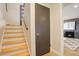 Modern entryway with wood stairs, a closet, and a glimpse into the living room at 2641 S Magnolia St, Denver, CO 80224