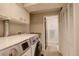 Laundry room with washer, dryer, cabinets, and granite countertops at 2641 S Magnolia St, Denver, CO 80224