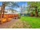 Spacious backyard featuring green grass, mature trees, a fire pit and a wood fence at 1241 Wabash St, Denver, CO 80220