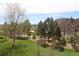Balcony view of the complex featuring manicured lawn, mature trees, and a walking path at 13952 E Marina Dr # 304, Aurora, CO 80014
