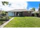 Well-maintained green backyard with brick accents, a patio, and a picnic table at 1666 S Bryant St, Denver, CO 80219