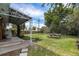 Green backyard with patio, trees, a picnic table, and a well-maintained lawn at 1666 S Bryant St, Denver, CO 80219