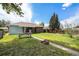 Lush backyard with a picnic table, brick house, and a well-manicured lawn at 1666 S Bryant St, Denver, CO 80219