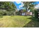 Beautiful green backyard with a shed, picnic table, and mature trees at 1666 S Bryant St, Denver, CO 80219