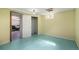Partially finished basement with light green flooring and a closet at 1666 S Bryant St, Denver, CO 80219