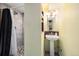 Cozy bathroom featuring a tiled shower with stylish fixtures and a pedestal sink at 1666 S Bryant St, Denver, CO 80219