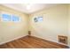 Sunny bedroom featuring hardwood floors, two windows, and yellow walls at 1666 S Bryant St, Denver, CO 80219