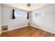 Bright bedroom with hardwood floors, windows, and a unique light fixture at 1666 S Bryant St, Denver, CO 80219