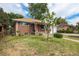 Charming brick home with a covered porch and well-manicured front lawn at 1666 S Bryant St, Denver, CO 80219