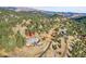 An aerial view of a luxurious house nestled in a wooded mountainside at 6057 Red Hill Rd, Boulder, CO 80302