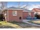 A brick home has a patio with furniture and a green lawn at 1580 Quince St, Denver, CO 80220