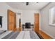 Well-lit bedroom with hardwood floors, featuring a desk, chair, and natural wood doors at 1580 Quince St, Denver, CO 80220