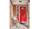 Close-up of a bright red front door with decorative glass, bench and a welcoming door mat at 1580 Quince St, Denver, CO 80220