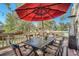 Outdoor deck featuring a dining set, potted plants, and a vibrant red umbrella at 25875 Buffalo Ln, Golden, CO 80401