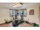 Exercise room with an elliptical machine, stationary bike, weights, and two windows with tree views at 25875 Buffalo Ln, Golden, CO 80401