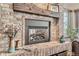 Close up on a brick fireplace with a wooden mantel and a modern black firebox at 25875 Buffalo Ln, Golden, CO 80401