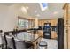 Open kitchen with granite countertops, black appliances, wood cabinets, bar seating, and a bright skylight at 25875 Buffalo Ln, Golden, CO 80401
