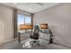 Home office featuring a modern glass desk, ergonomic chair, and natural light at 8982 Delacorte St, Littleton, CO 80129