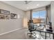 Home office featuring a modern glass desk, ergonomic chair, and natural light at 8982 Delacorte St, Littleton, CO 80129
