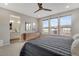 Bright main bedroom featuring a ceiling fan, three windows with neighborhood views, and an ensuite bathroom at 8982 Delacorte St, Littleton, CO 80129