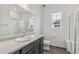 Modern bathroom featuring gray vanity, white walls, and a glass enclosed shower with a bench at 1613 Bloom St, Brighton, CO 80601