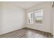 A well-lit bedroom has wood look floors and a large window at 1613 Bloom St, Brighton, CO 80601