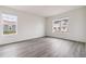 Bright bedroom featuring two large windows and gray, wood-look flooring at 1613 Bloom St, Brighton, CO 80601
