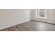 Cozy bedroom shows wood-look floors and bright natural light from a single window at 1613 Bloom St, Brighton, CO 80601
