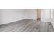 Spacious, bright bedroom with light gray wood-look flooring and a bathroom with vanity at 1613 Bloom St, Brighton, CO 80601