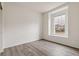 A bright bedroom features wood-look flooring and natural light from the window at 1613 Bloom St, Brighton, CO 80601