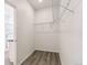 A walk-in closet features open shelving for storage and wood-look flooring throughout at 1613 Bloom St, Brighton, CO 80601